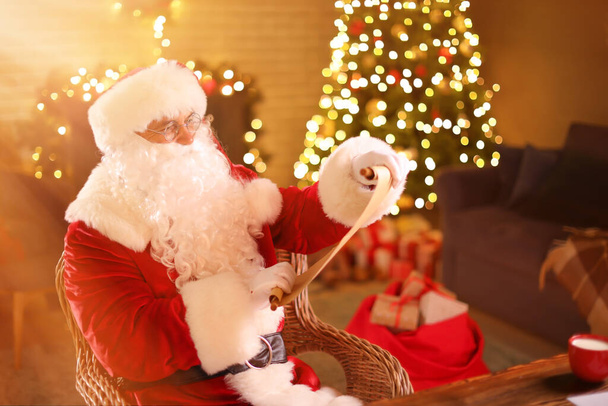 Weihnachtsmann liest Brief an Heiligabend zu Hause - Foto, Bild