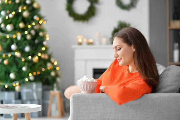 Beautiful young woman with cup of hot cacao drink at home on Christmas eve - Foto, immagini