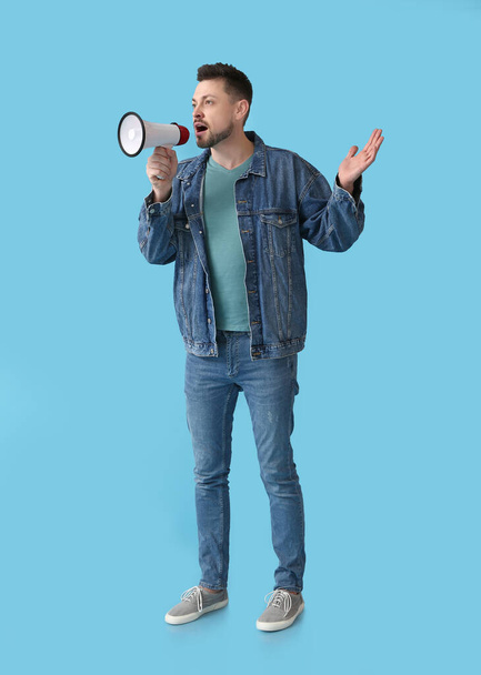 Emotionele man met megafoon op kleur achtergrond - Foto, afbeelding