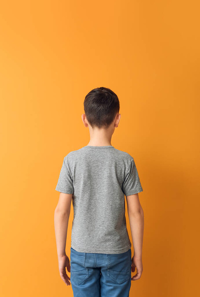 Little boy in stylish t-shirt on color background, back view - 写真・画像