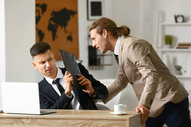 Man seducing his male colleague in office. Concept of harassment - Photo, image