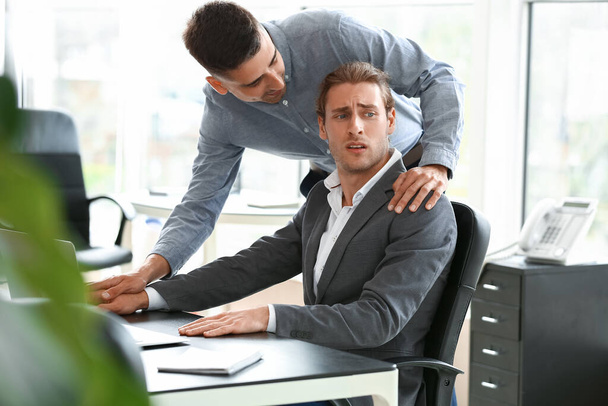 Man harassing his male colleague in office - Photo, Image
