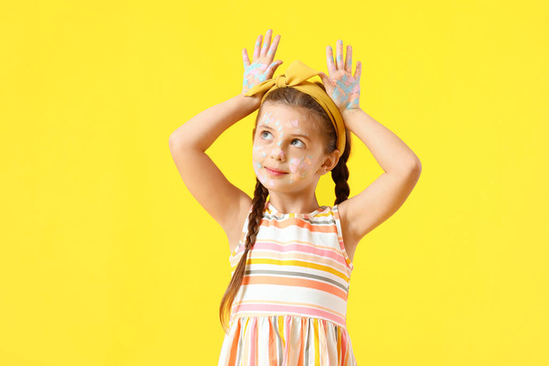 Смішна дівчинка в фарбі на жовтому тлі
 - Фото, зображення