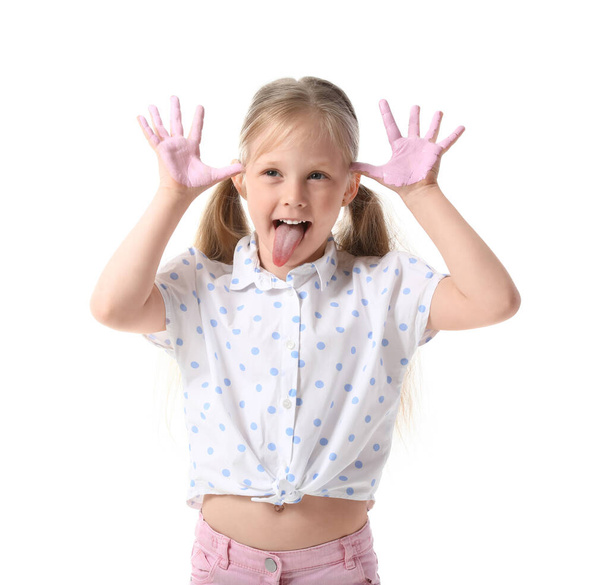 Klein meisje met handen in roze verf grimmig op witte achtergrond - Foto, afbeelding