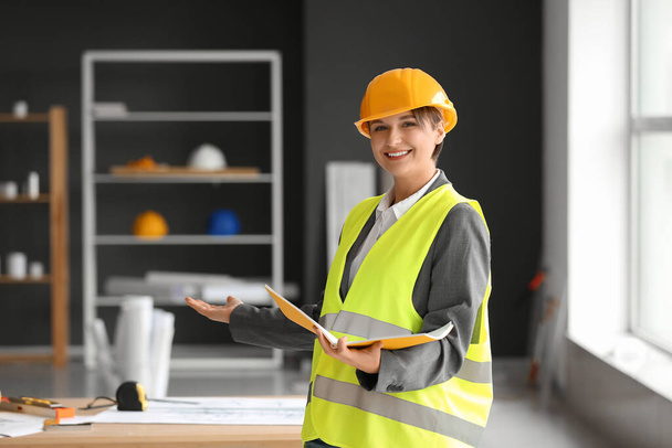 Žena stavební dělnice se složkou v kanceláři - Fotografie, Obrázek