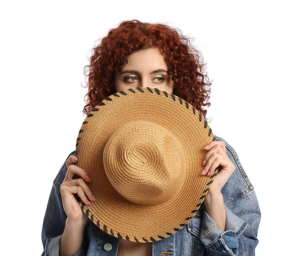 Pretty woman with curly hair holding wicker hat on white background - Foto, afbeelding