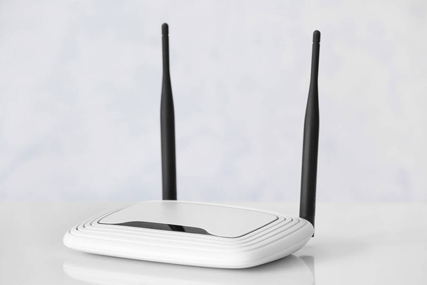 Moderno router wi-fi en mesa cerca de la pared blanca - Foto, Imagen
