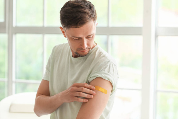 Man with medical patch on his arm in clinic - Valokuva, kuva