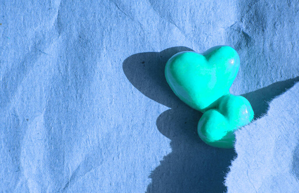 Two hearts on paper with space to copy. The concept of Valentine's Day or giving on Tuesday, blue tinted. - Photo, Image