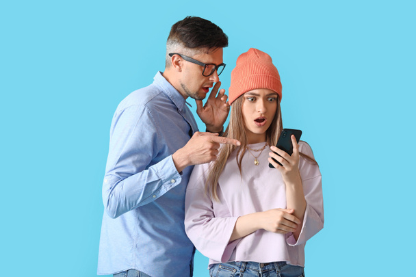 Розтягування людей телефоном на кольоровому фоні
 - Фото, зображення