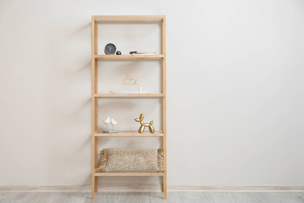 Unidade de prateleira de madeira elegante com decoração perto da parede clara - Foto, Imagem