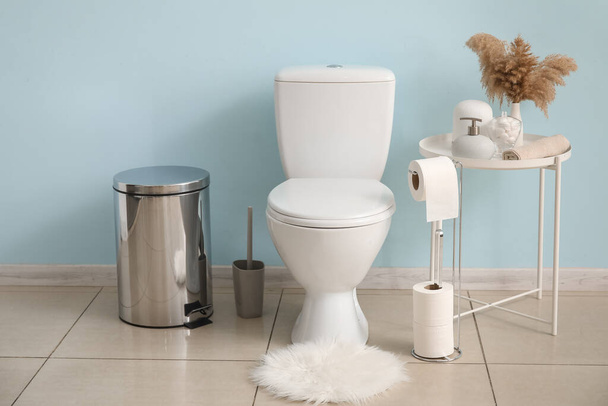 Light modern restroom with toilet paper holder and table with accessories - Photo, Image
