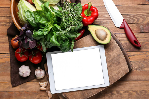 Digitaal receptenboek, greens, groenten en mes op houten ondergrond - Foto, afbeelding