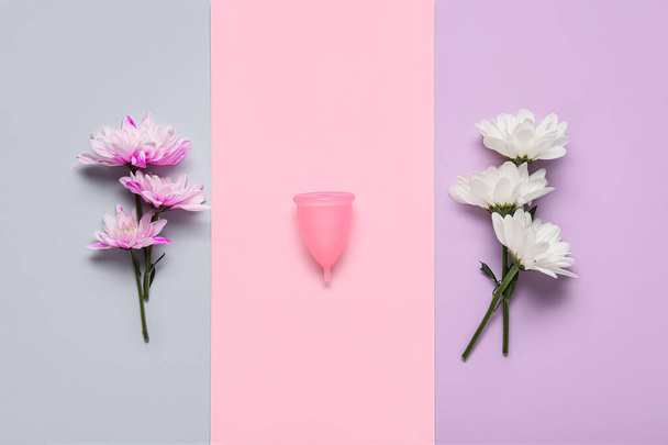 Copo menstrual e flores no fundo de cor - Foto, Imagem