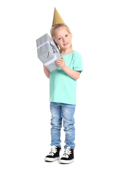 Lustiges kleines Mädchen im Partyhut mit Geburtstagsgeschenk auf weißem Hintergrund - Foto, Bild