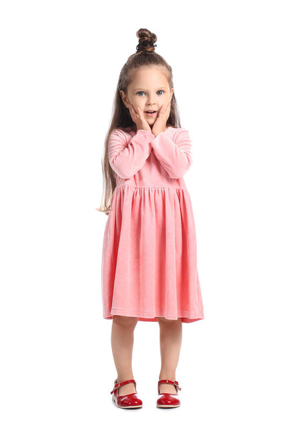 Yllättynyt pieni tyttö vaaleanpunainen mekko valkoisella taustalla - Valokuva, kuva