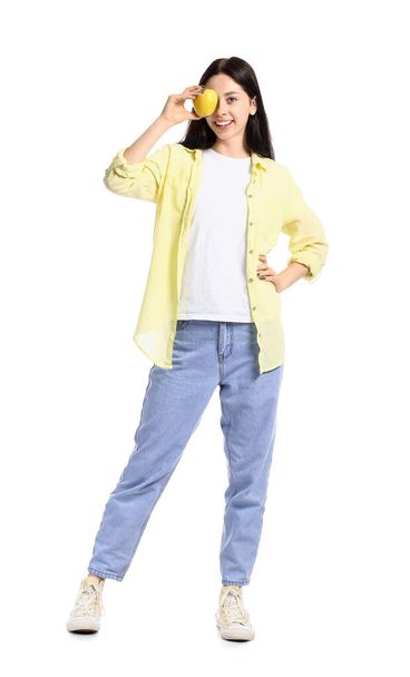 Beautiful teenage girl with yellow apple on white background - Photo, image