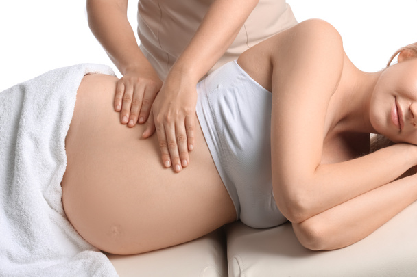 Jovem grávida tendo massagem contra fundo branco - Foto, Imagem