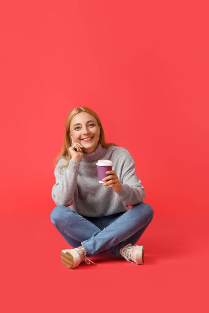 Όμορφη ώριμη γυναίκα με φλιτζάνι καφέ στο φόντο χρώμα - Φωτογραφία, εικόνα