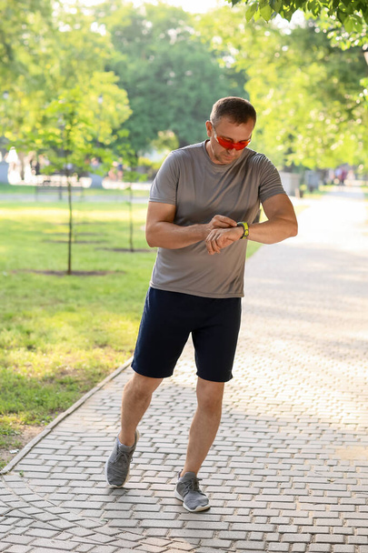 Male runner checking pulse outdoors - Photo, Image