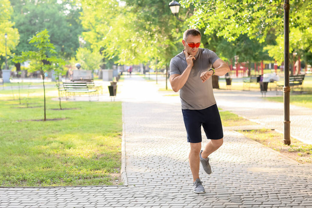 mężczyzna biegacz sprawdzanie pulsu na zewnątrz - Zdjęcie, obraz