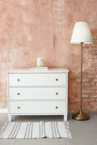 Chest of drawers and torchier near pink wall - Photo, Image