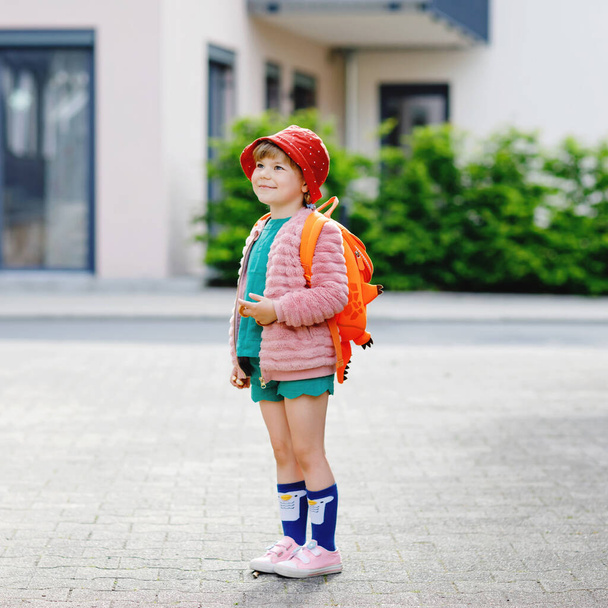 Χαριτωμένο κοριτσάκι που πάει σχολείο. Υγιές παιδί μικρής ηλικίας με τα πόδια στο νηπιαγωγείο και νηπιαγωγείο. Ευτυχισμένο παιδί με σακίδιο πλάτης στο δρόμο της πόλης, σε εξωτερικούς χώρους. - Φωτογραφία, εικόνα