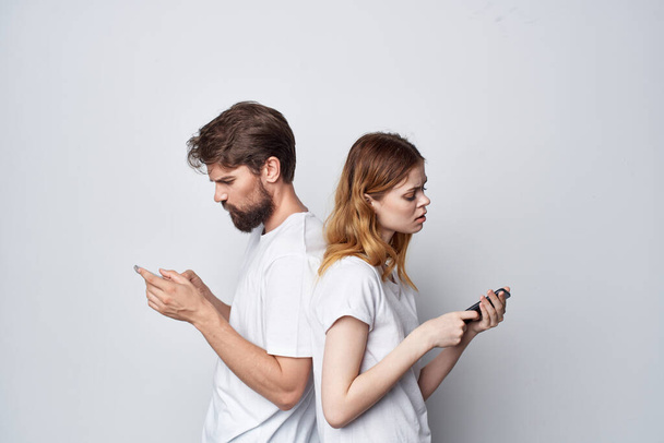 homme et femme famille avec téléphones en main communication lumière arrière-plan - Photo, image