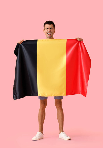 Emocjonalny mężczyzna z flagą Belgii na tle koloru - Zdjęcie, obraz
