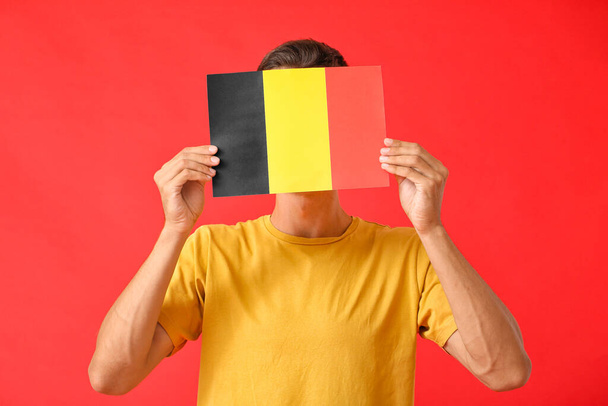 Junger Mann mit belgischer Flagge auf farbigem Hintergrund - Foto, Bild