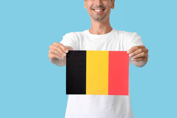 Jeune homme avec drapeau de la Belgique sur fond de couleur - Photo, image