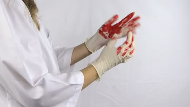 nő sebész orvos fehér köntöst levenni kezét véres kesztyű - Felvétel, videó