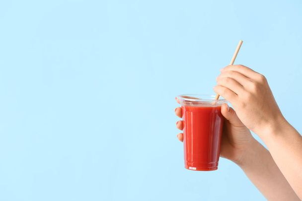 Female hands with glass of healthy juice on color background - Photo, Image