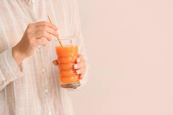 色の背景に健康的なジュースのガラスを持つ女性 - 写真・画像