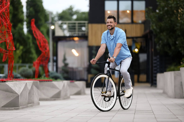 Человек на велосипеде по улице города
 - Фото, изображение
