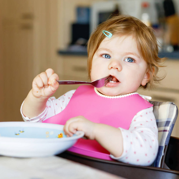 Adorable baby girl eating from spoon mashed vegetables and puree. food, child, feeding and people concept - Photo, Image