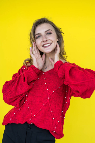 muoti nainen klassinen punainen neulottu villapaita poseeraa ja hymyilee keltaisella taustalla. elämäntapa - Valokuva, kuva