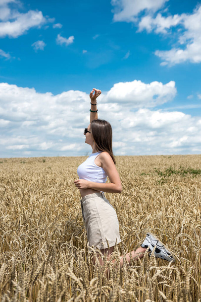 Ritratto di giovane donna sportiva sul campo di grano in estate. stile di vita - Foto, immagini