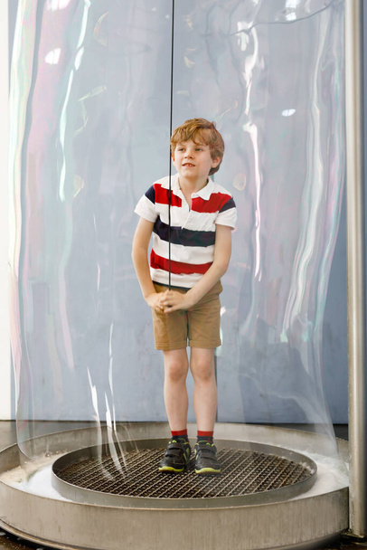 Niño rubio jugando con burbujas de jabón enorme construcción en el interior. Feliz niño sonriente saludable divirtiéndose con experimentos - Foto, Imagen