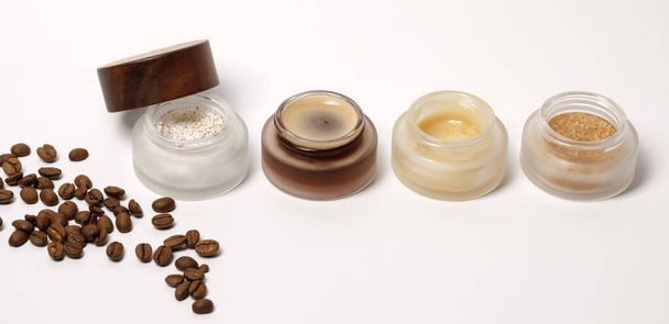 Brown sugar, coffee and honey ingredients for scrub in glass jars with wooden lid for homemade cosmetic on background. Beauty, Spa, skin care, zero waste packaging concept - Valokuva, kuva