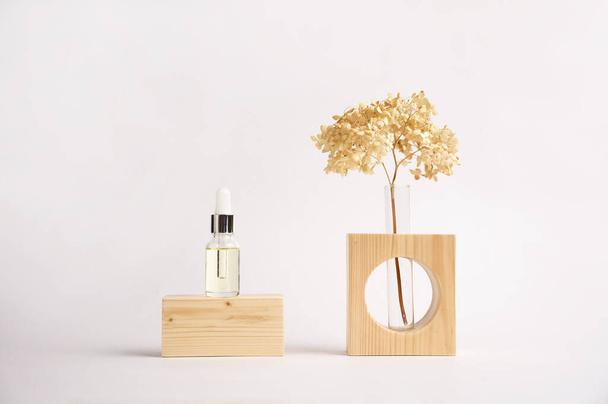 Wooden podium with cosmetic bottle, dried flower in the vase on grey background for product presentation. - 写真・画像