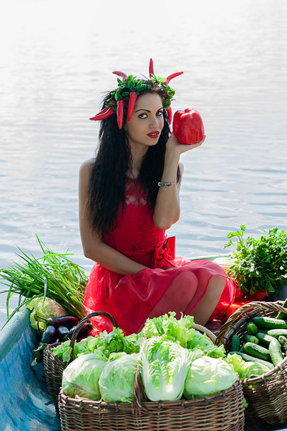 Girl holding a pepper sitting in a boat - Photo, Image