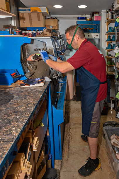 Jeune cordonnier réparer les chaussures dans l'atelier de réparation. - Photo, image