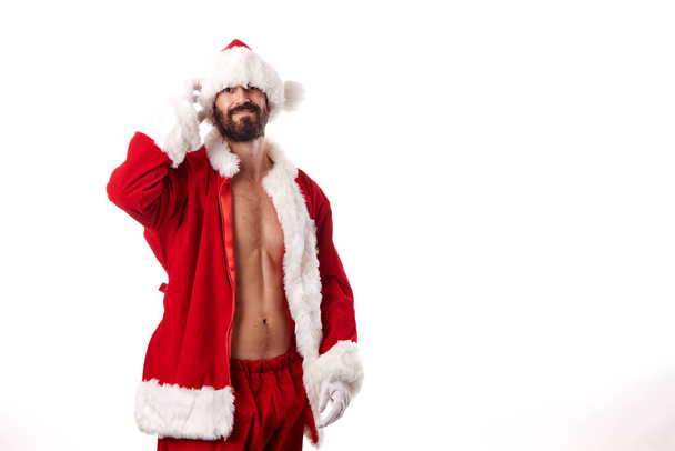 Santa Claus bodybuilder showing off his athletic body on a white background - Zdjęcie, obraz