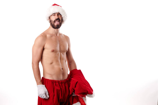 Бодибилдер Санта-Клауса показывает свое спортивное тело на белом фоне - Фото, изображение