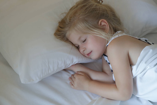 Süßes kleines Mädchen schläft im Bett - Foto, Bild