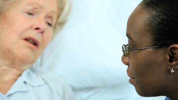 それ以上の年齢の患者の病院のベッドの安心思いやりのある看護師 - 映像、動画