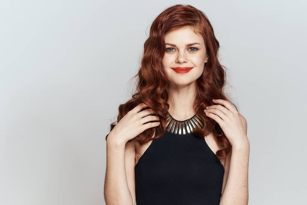 red-haired woman in black dress red lips glamor posing - 写真・画像