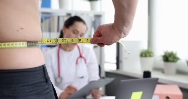 Lékař provádí lékařské vyšetření muže s nadváhou na břiše 4k filmu - Záběry, video