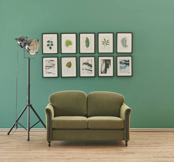 Зелена стіна з багатьма чорними декоративними рамками і концепцією дивана
. - Фото, зображення